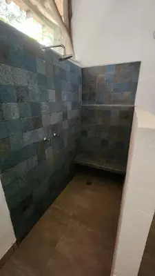 a small bathroom with a bench in the corner at Casa Kiwi Jungle Lodge in San Francisco