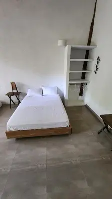 a bedroom with a bed and a chair in it at Casa Kiwi Jungle Lodge in San Francisco