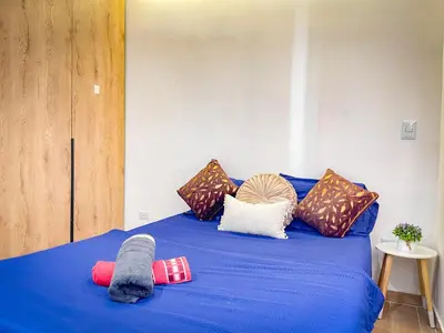 a blue bed with a bunch of pillows on it at Apt luxe laurles estadio 3alcobas in Medellín