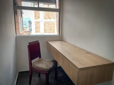 a desk and a chair in a room with a window at Apt luxe laurles estadio 3alcobas in Medellín