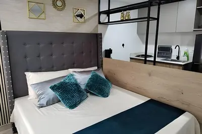 a bedroom with a large bed with two blue pillows at Acogedor Loft en la floresta cerca al metro in Medellín