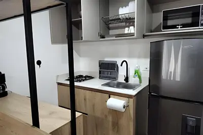 a small kitchen with a sink and a refrigerator at Acogedor Loft en la floresta cerca al metro in Medellín