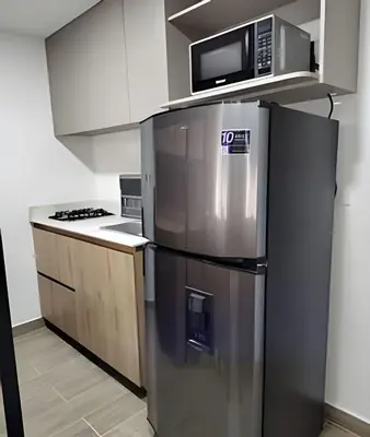 a kitchen with a stainless steel refrigerator and a microwave at Acogedor Loft en la floresta cerca al metro in Medellín
