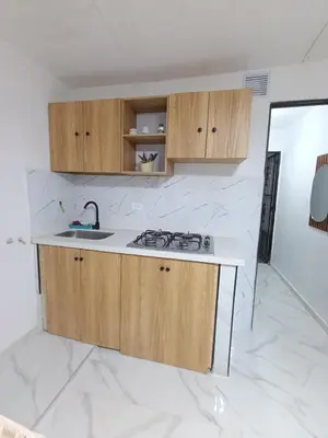 a kitchen with wooden cabinets and a sink at E2V LINDO y RENOVADO APARTAMENTO EN LAURELES ESTADiO in Medellín