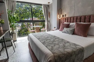 a bedroom with a large bed and a large window at The O by Seekers Medellín in Medellín