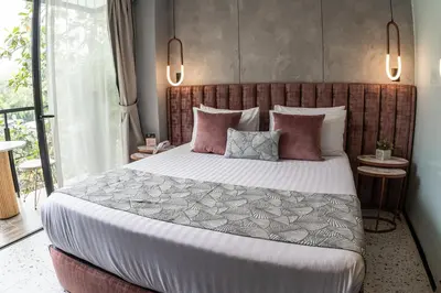 a bedroom with a large bed with pink pillows at The O by Seekers Medellín in Medellín