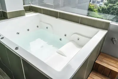 a white bath tub in a bathroom with a window at The O by Seekers Medellín in Medellín