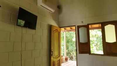 a room with a tv on the wall and a door at HOTEL CAMPESTRE LAS CAVERNAS in Mesa del Norte