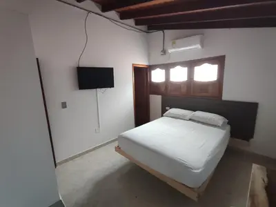 a bedroom with a white bed and a window at HOTEL CAMPESTRE LAS CAVERNAS in Mesa del Norte