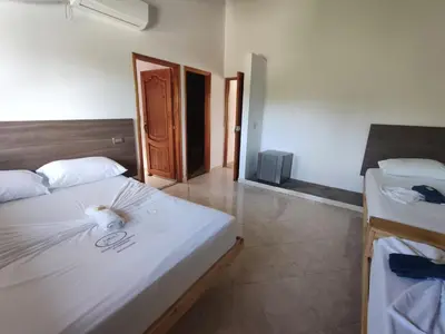 a bedroom with a large white bed and a room with two beds at HOTEL CAMPESTRE LAS CAVERNAS in Mesa del Norte