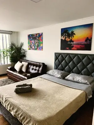a bedroom with a large bed and a couch at Aparta Estudio Confortable, Lujoso y Comodo en Milan in Manizales