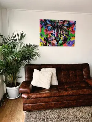 a couch in a living room with a painting of a cat at Aparta Estudio Confortable, Lujoso y Comodo en Milan in Manizales