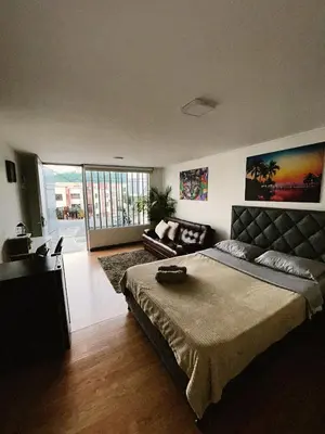 a bedroom with a large bed and a couch at Aparta Estudio Confortable, Lujoso y Comodo en Milan in Manizales