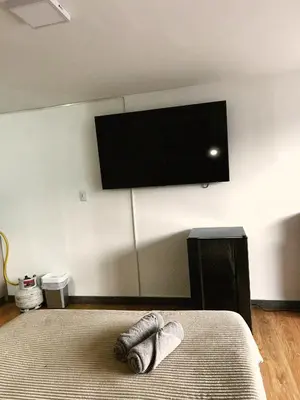 a bedroom with a bed with a flat screen tv on the wall at Aparta Estudio Confortable, Lujoso y Comodo en Milan in Manizales