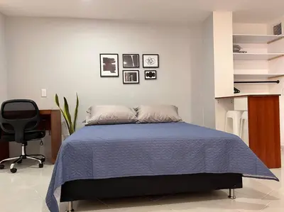 a bedroom with a bed and a desk and a chair at Comfy loft in Laureles in Medellín