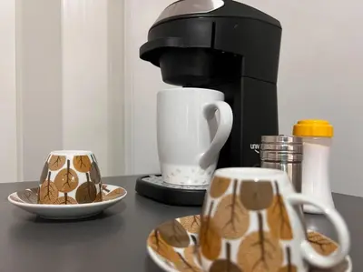 a coffee maker and two cups on a counter at Comfy loft in Laureles in Medellín