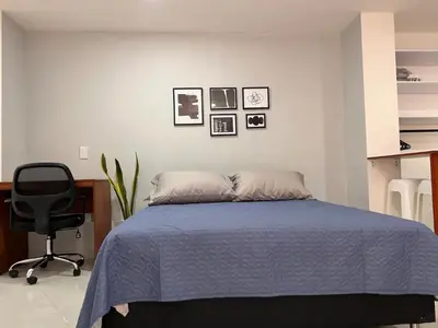 a bedroom with a bed and a desk and a chair at Comfy loft in Laureles in Medellín
