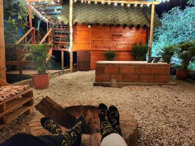 a person with their feet up on a fire pit at Cabaña en la Naturaleza con Jacuzzi - Santa Elena in Medellín
