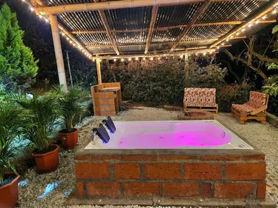 a hot tub in a backyard with a pergola at Cabaña en la Naturaleza con Jacuzzi - Santa Elena in Medellín