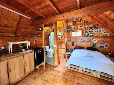 a bedroom with a bed in a wooden cabin at Cabaña en la Naturaleza con Jacuzzi - Santa Elena in Medellín
