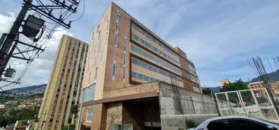 a tall brick building with glass windows in a city at 1BR Air Conditioned Studio Buenos Aires in Medellín