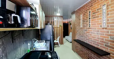 a room with a brick wall and a kitchen at 1BR Air Conditioned Studio Buenos Aires in Medellín