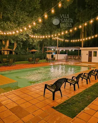 a swimming pool with benches and lights in a park at Hotel Villa Santa María in Santa Fe de Antioquia