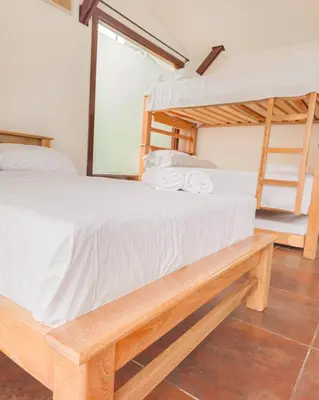 a bedroom with a bunk bed with white sheets at Hotel Villa Santa María in Santa Fe de Antioquia