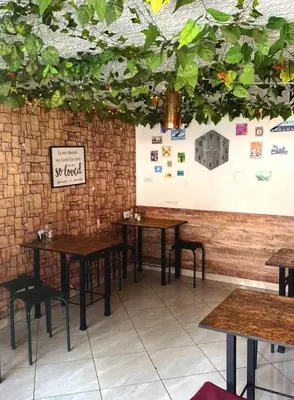 a dining room with tables and a wall with plants at Hotel San Pablo boutique H9 in Medellín