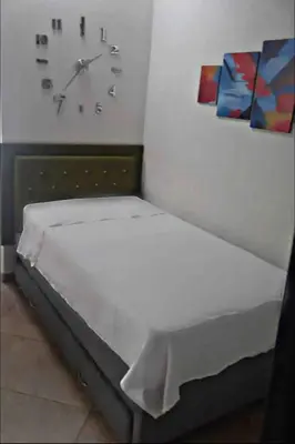 a room with a bed with a clock on the wall at Hermoso apartamento con estacionamiento in Medellín