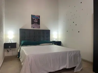a bedroom with a large bed and two lamps at Hermoso apartamento con estacionamiento in Medellín