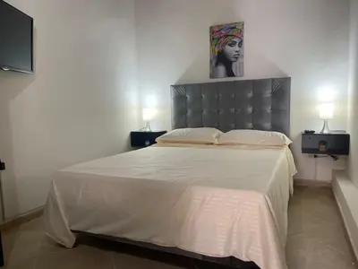 a bedroom with a bed with a headboard and two lamps at Hermoso apartamento con estacionamiento in Medellín