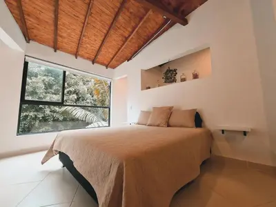 a bedroom with a large bed with a large window at Duplex apartment in Medellín