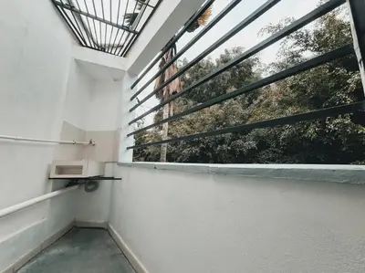 a balcony with a window with a view of trees at Duplex apartment in Medellín