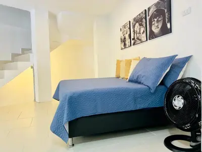a bedroom with a blue bed and a staircase at Duplex apartment in Medellín