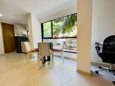 a living room with a table and chairs and a window at Duplex apartment in Medellín