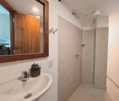 a bathroom with a sink and a shower with a mirror at Duplex apartment in Medellín