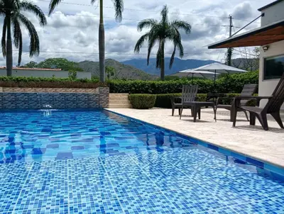 a blue swimming pool with chairs and a table at Antokia in Santa Fe de Antioquia