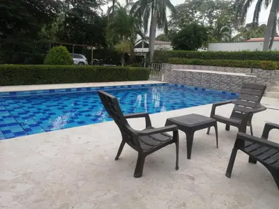 a pool with chairs and a table next to it at Antokia in Santa Fe de Antioquia