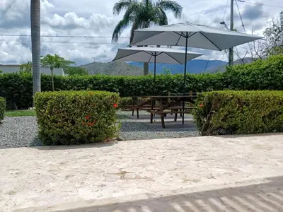 a picnic table with an umbrella and some bushes at Antokia in Santa Fe de Antioquia