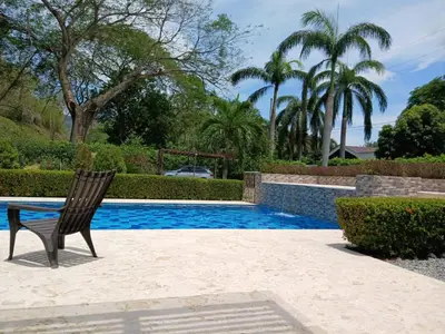 a wooden chair sitting next to a swimming pool at Antokia in Santa Fe de Antioquia