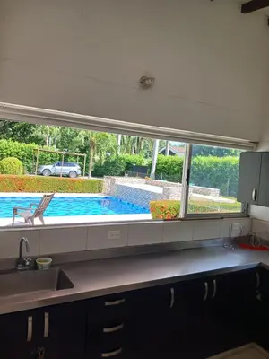 a kitchen with a view of a swimming pool through a window at Antokia in Santa Fe de Antioquia