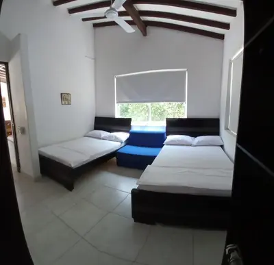 a room with two beds and a window at Antokia in Santa Fe de Antioquia
