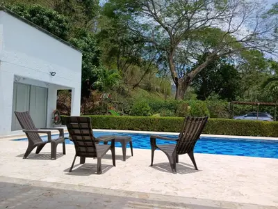 a table and chairs next to a swimming pool at Antokia in Santa Fe de Antioquia