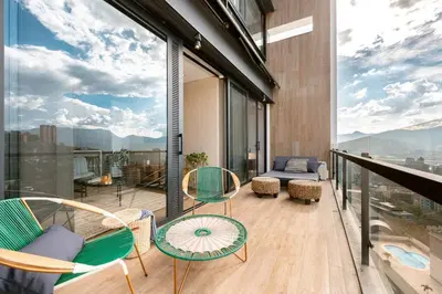 a balcony with chairs and a table and a couch at Energy Living - Ultimate Condo in Medellin in Medellín
