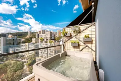 a bath tub on a balcony with a view of a city at Energy Living - Ultimate Condo in Medellin in Medellín