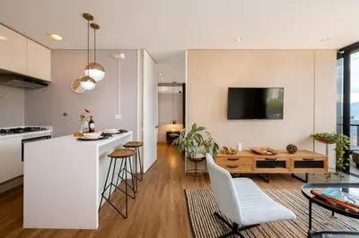 a kitchen and living room with a counter and a table at Energy Living - Ultimate Condo in Medellin in Medellín