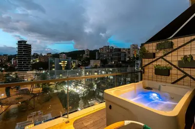 a bath tub on a balcony with a view of a city at Energy Living - Ultimate Condo in Medellin in Medellín