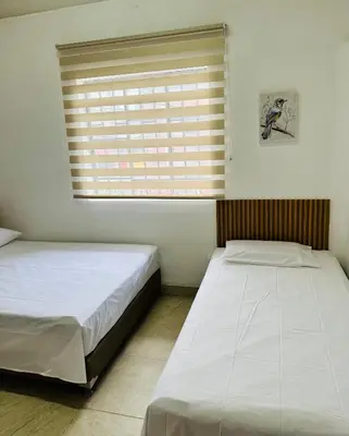 two twin beds in a room with a window at Apartamento en San Diego La Candelaria cerca al centro de Medellín in Medellín