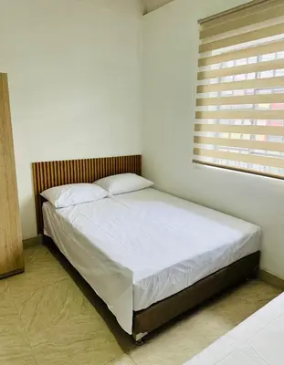 a bed in a white room with a window at Apartamento en San Diego La Candelaria cerca al centro de Medellín in Medellín